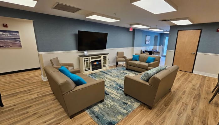 Bright common area with modern furnishings and a TV