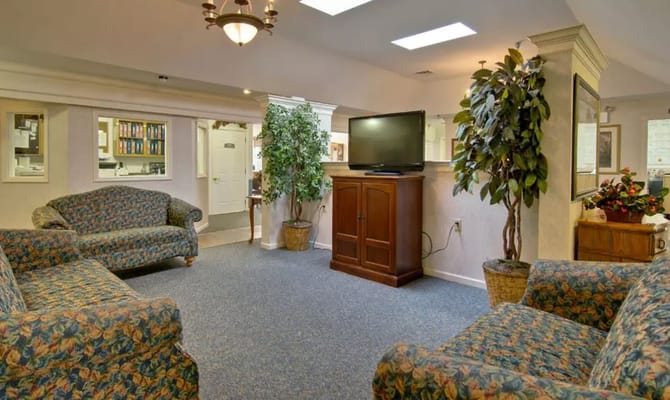 Lounge area with floral-patterned sofas and a television.