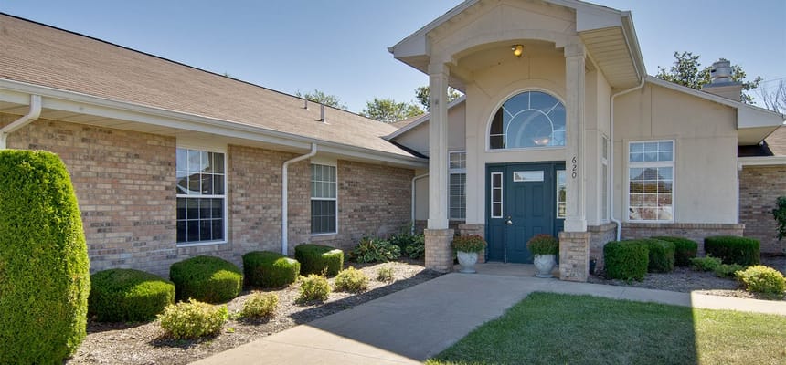 Entrance view of Highland Crest Senior Living with well-maintained landscaping.