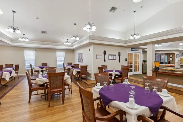 Bright dining area with purple tablecloths and wooden chairs