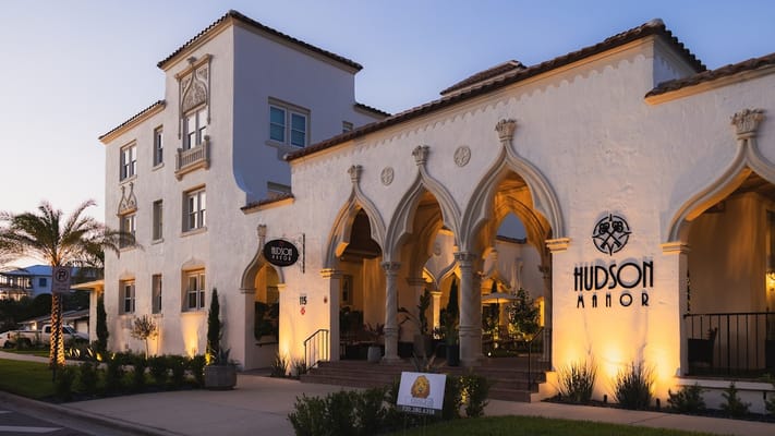 Exterior view of Hudson Manor Assisted Living at sunset