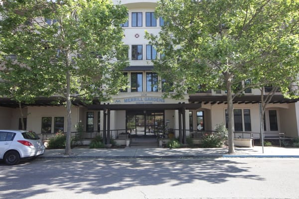 Main entrance of Merrill Gardens at Willow Glen with greenery