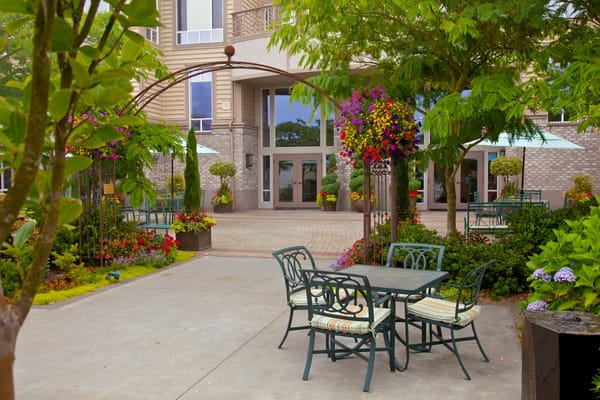 Outdoor seating area with vibrant flowers and landscaping