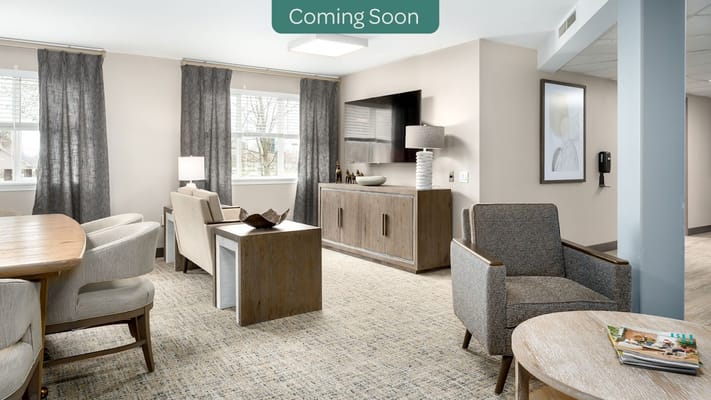 A well-furnished living room with a dining area and window curtains.