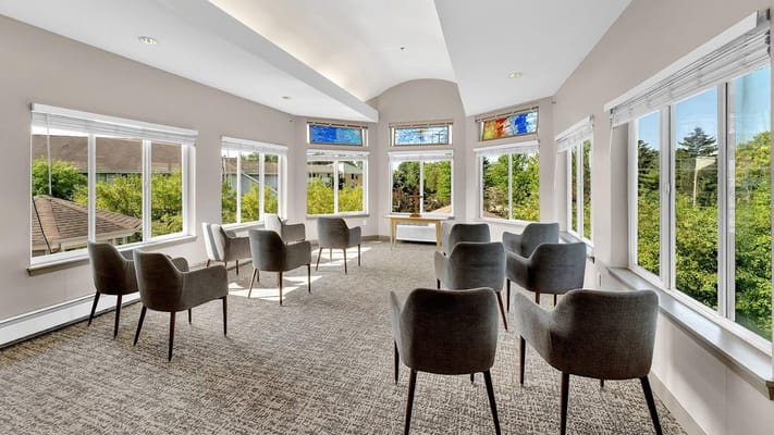 Brightly lit common area with chairs and large windows