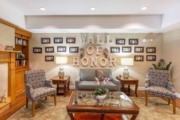 Cozy lounge area featuring the Wall of Honor with framed photos and seating.