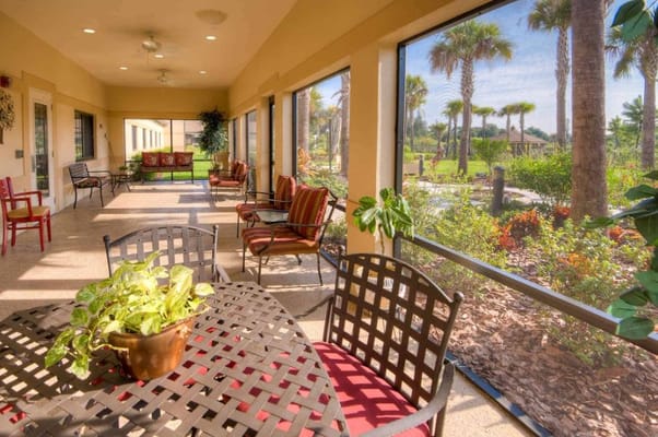 Spacious veranda with seating and outdoor view at Inspired Living at Hidden Lakes.