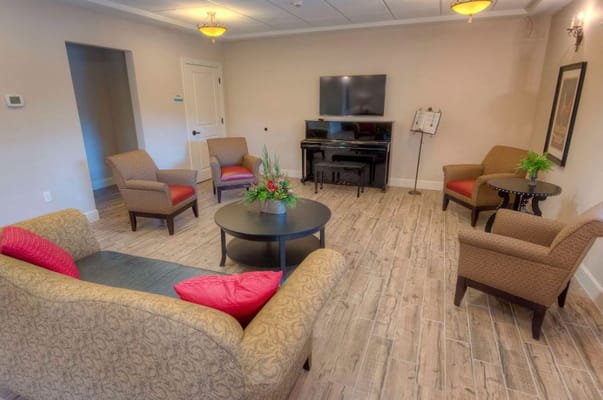 Bright common area with seating and piano