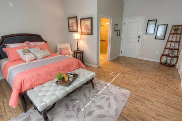 Brightly decorated private resident room with bed and seating area