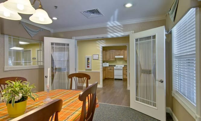 Bright dining area with a table and kitchen entrance
