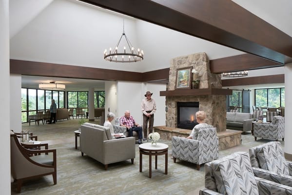 Seniors relaxing in a lounge area with a fireplace