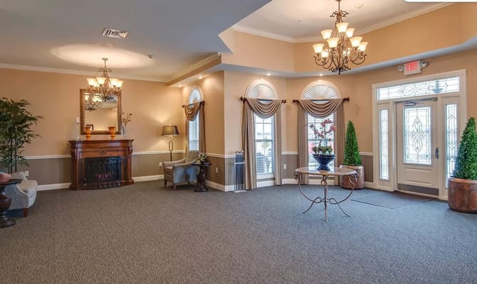 Cozy lobby area with a chandelier, seating, and decorative plants.