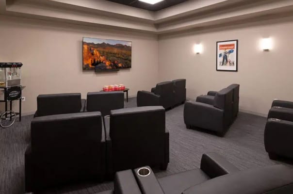 A media room featuring comfortable seating and a large screen.