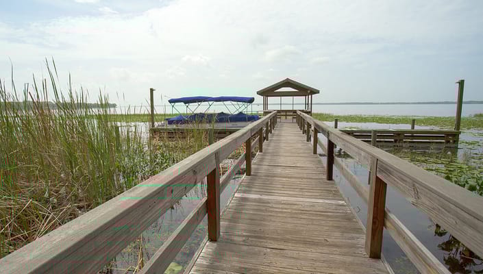 A wooden pier leading to a calm lake
