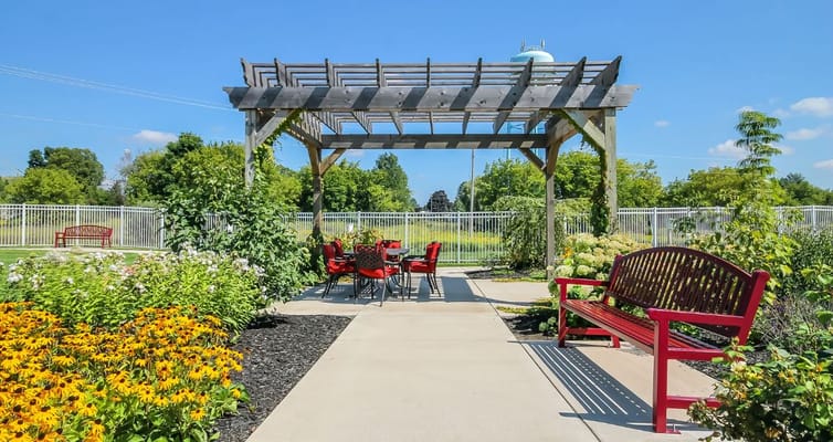 Outdoor seating area with pergola and flowers at Lakeview Terrace