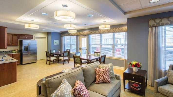 A bright common area with seating and dining tables