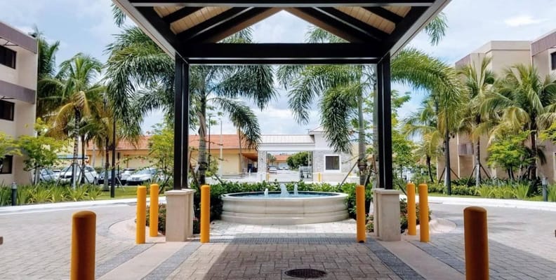 Entrance area with a fountain and palm trees.