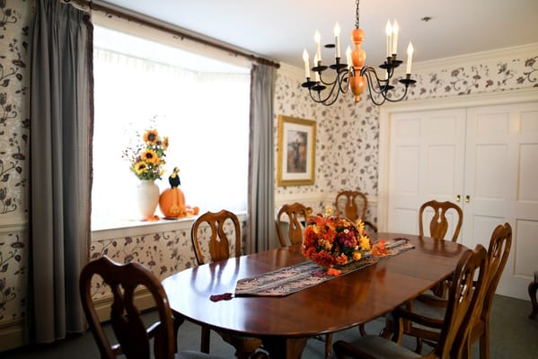 Well-decorated dining room with elegant wooden table and floral centerpiece