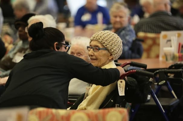 A resident interacting with staff in a common area