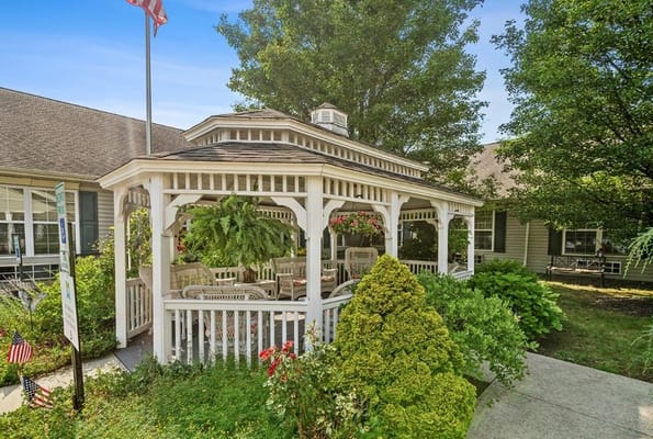 White gazebo surrounded by greenery and flowers