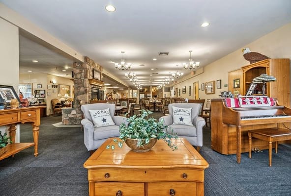 Spacious common area featuring comfortable seating and a piano