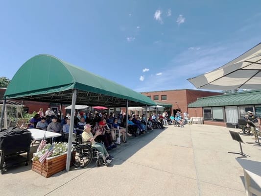 Outdoor gathering with residents watching a performance