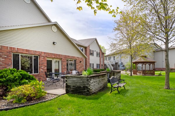 Backyard seating area with gazebo and greenery at Mankato Lodge.
