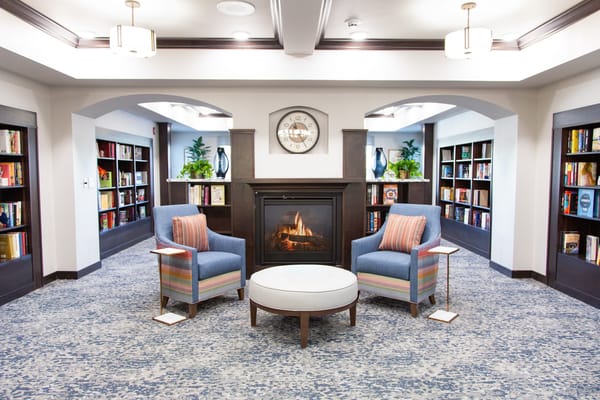 Cozy lounge area with two chairs and a fireplace in the library
