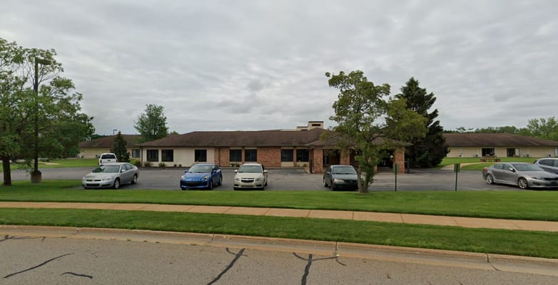 Front view of Meadowlark Retirement Village building with cars parked