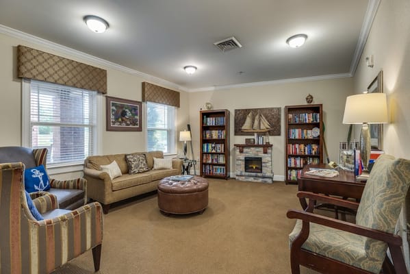 Cozy living room with seating, bookshelves, and a fireplace