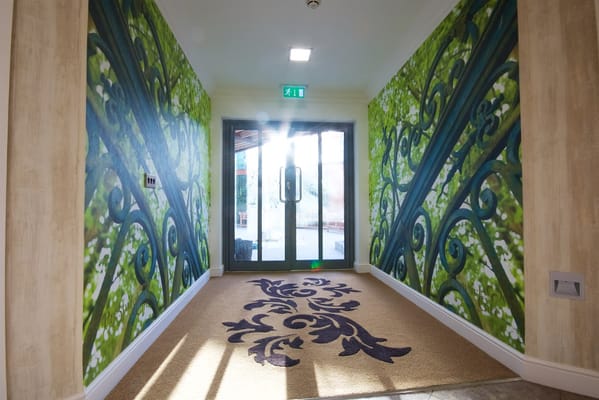 Bright hallway featuring vibrant green wall murals