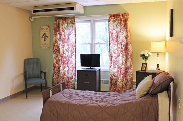 Cozy private resident room with a bed and chair