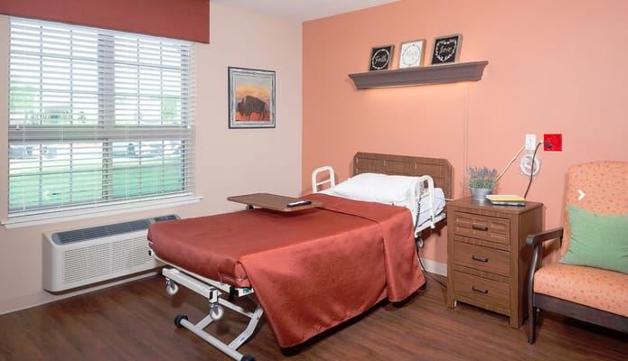 A comfortable patient room featuring a bed and cozy furnishings.