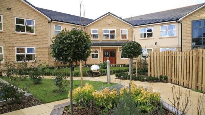 Exterior view of a senior living facility with landscaped gardens