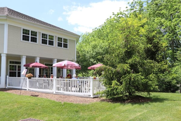 Residents enjoying outdoor space with umbrellas and greenery