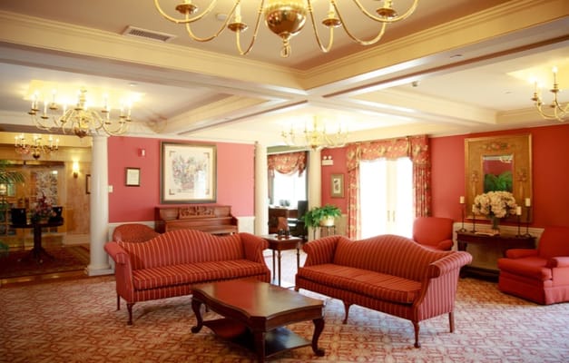 A cozy living room area with red sofas and chandeliers