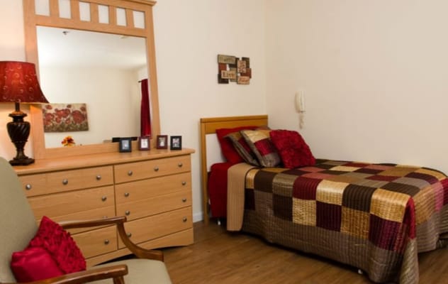 Cozy interior of a resident room with a bed and dresser