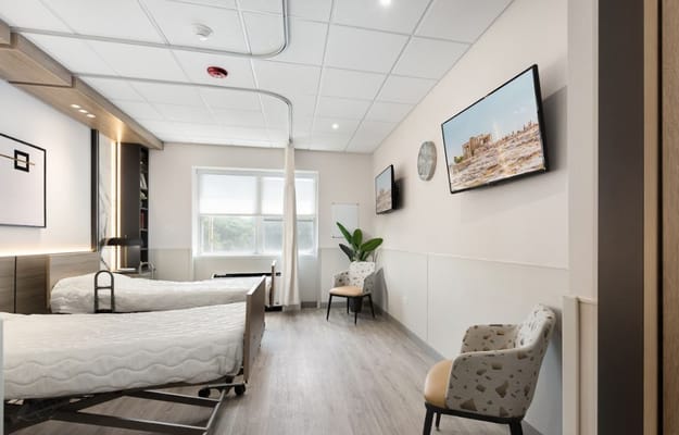 A brightly lit shared room with two beds