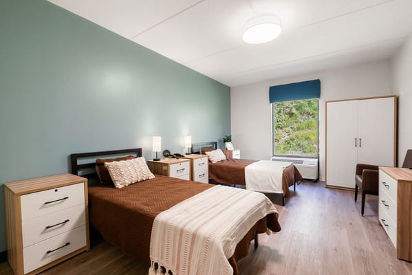 A well-furnished resident room with two beds