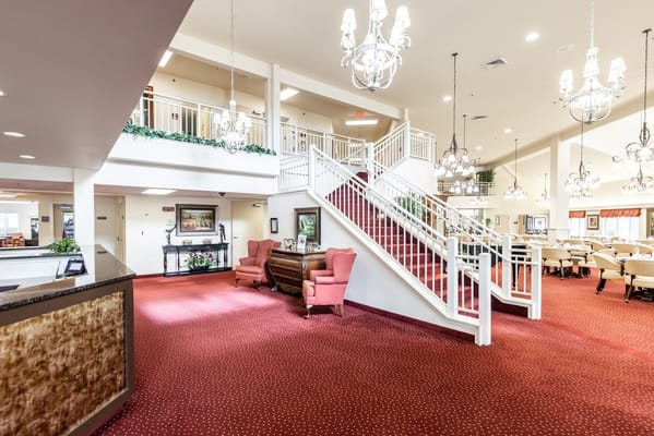 Lobby with red carpet, chandelier lighting, and seating area