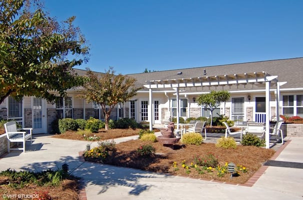 Outdoor courtyard with seating and garden plants at Myrtle Beach Grove Senior Living.