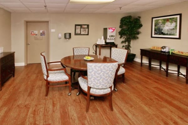 A round table surrounded by chairs in a common area.