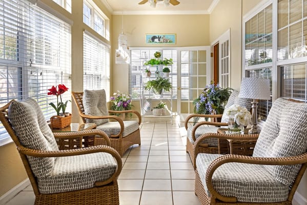 Cozy sunroom with wicker chairs and greenery