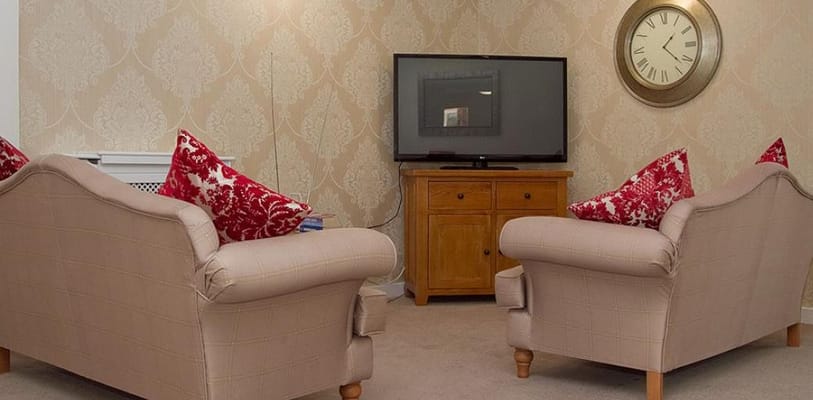 Cozy lounge with two chairs and a TV