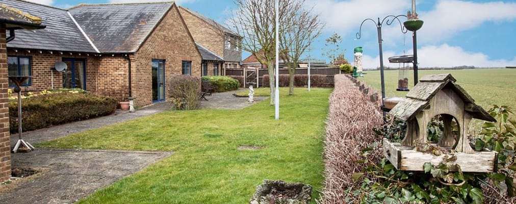 Well-maintained garden with seating area and bird feeders.