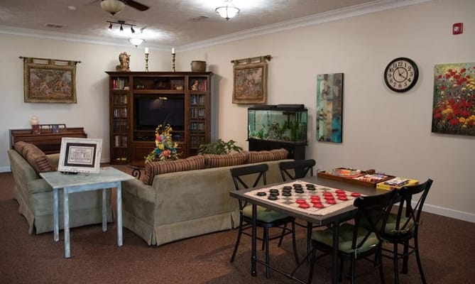 Cozy lounge area with couches, a game table, and a fish tank.