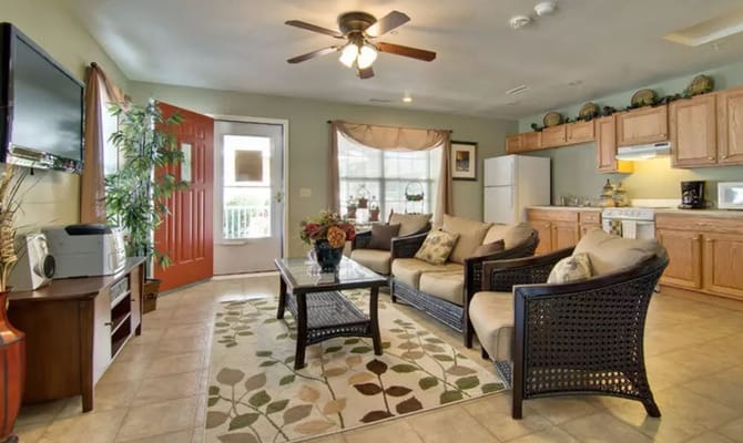 Comfortable living room with sofas, coffee table, and kitchen area.