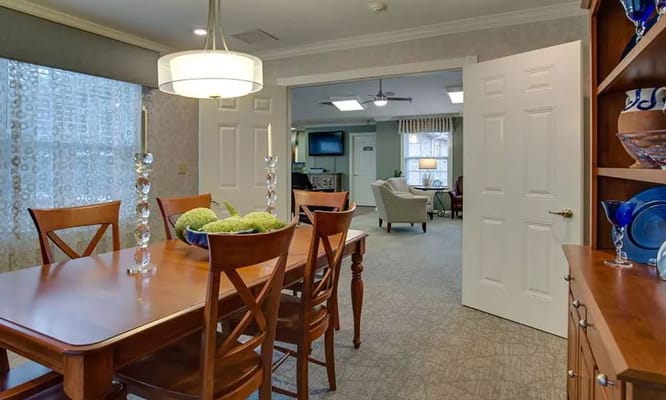 Cozy dining room with a wooden table and chairs, leading into a living area.