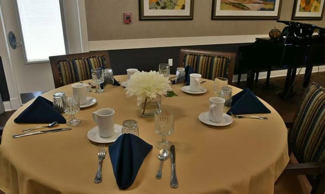 Set dining table with blue napkins and flower centerpiece