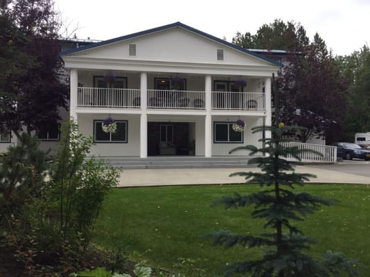 Front view of Northern Comfort Assisted Living with balcony and garden